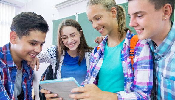 Gruppe Schüler:innen mit Tablet in Klasse