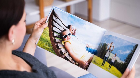 Frau schaut Fotobuch an &copy; Andrey Popov, stock.adobe.com