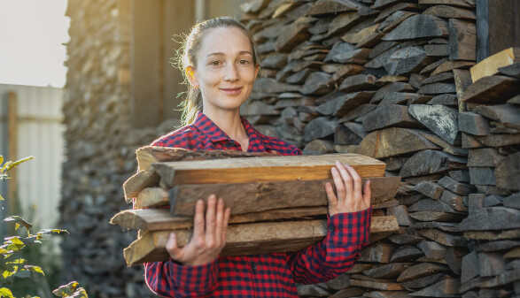 Junge Frau trägt Brennholz