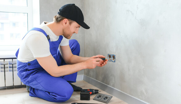 Elektriker montiert eine Steckdose