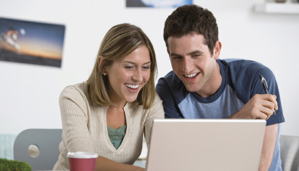 Mann und Frau sitzen vor Laptop
