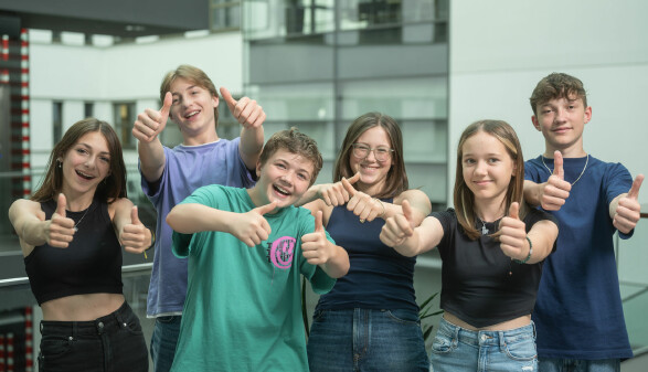 Eine Gruppe Jugendlicher steht im Innenhof der AK Linz