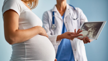 Ärztin bespricht mit Schwangeren Ultraschallbild