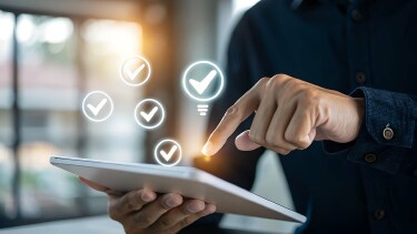 Mensch hält Tablett in der Hand, hat leuchtenden Finger und fliegende Häkchen in weißen Kreisen