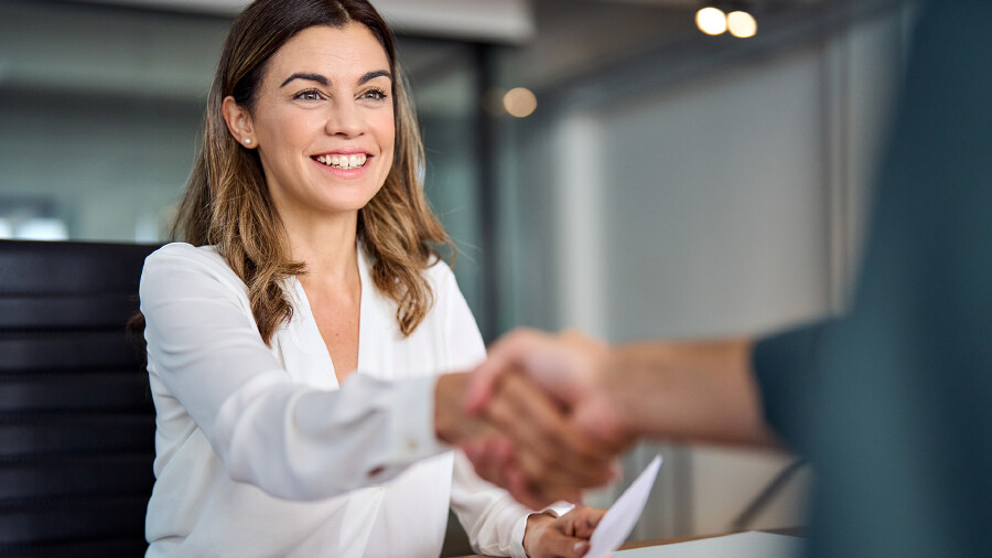 Beraterin sch&uuml;ttelt Kunden die Hand