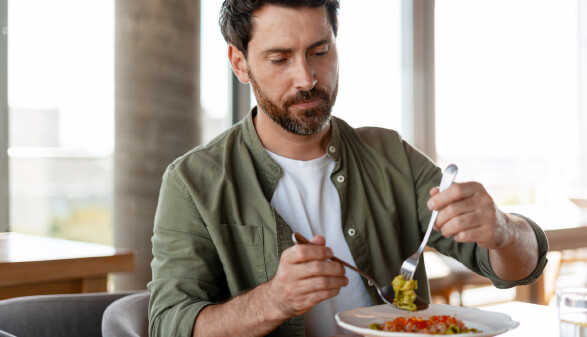 Mann isst Pesto-Nudeln