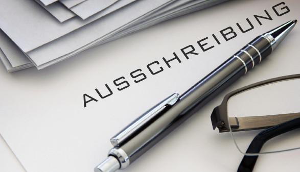 © Butch, stock.adobe.com Text "Ausschreibung" mit Kugelschreiber und Brille © Butch, stock.adobe.com