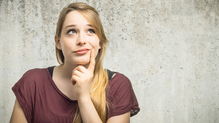 Junge Frau blickt nachdenkend nach rechts oben