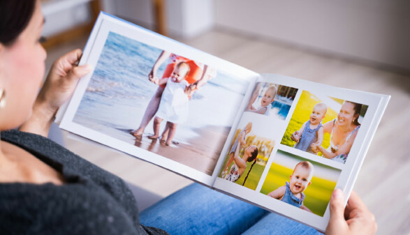 Eine Frau schaut sich ein Fotobuch an.