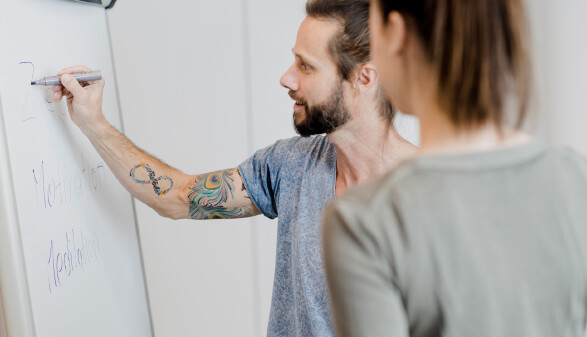 Person schreibt auf Flipchart