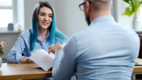 Junge Frau mit blauen Haaren beim Vorstellungsgespr&auml;ch.
