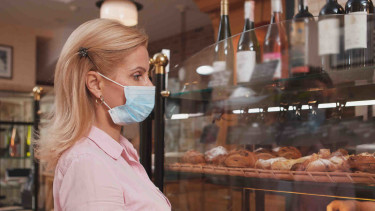 Frau mit Maske kauft in einer Bäckerei ein © Ihor, stock.adobe.com