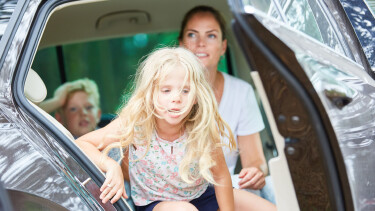 Kind mit Reisekrankheit steigt aus dem Auto