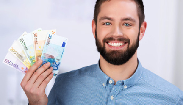 Mann mit Vollbart hält Euro-Geldscheine in der Hand