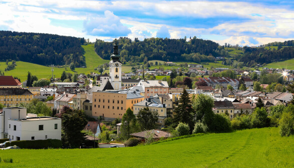 Panoramaansicht der Stadt Freistadt in Oberösterreich mit historischen Gebäuden und grüner Hügellandschaft im Hintergrund.