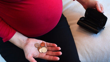 Schwangere zeigt Restmünzen ihrer Geldtasche