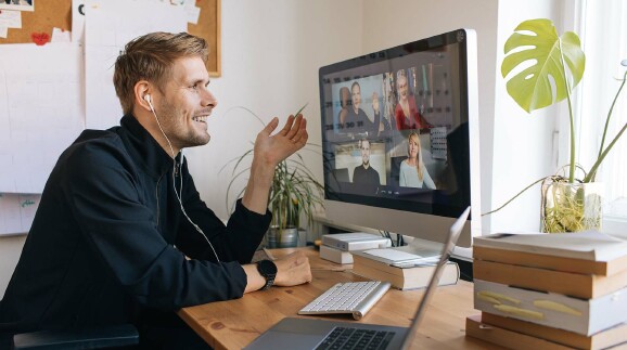 Ein Mann sitzt w&auml;hrend einer Videokonferenz vor dem Bildschirm.
