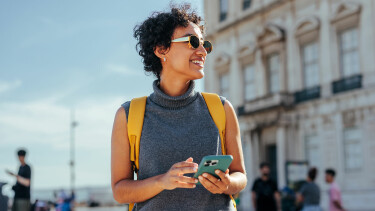 Junge Frau befindet sich im Urlaub und verwendet Handyroaming