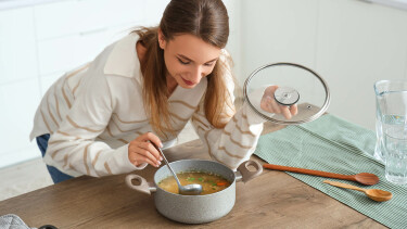 Frau kocht Suppe