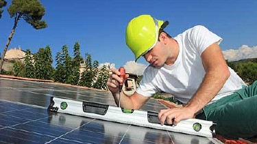 Bauarbeiter montiert Solaranlage am Dach