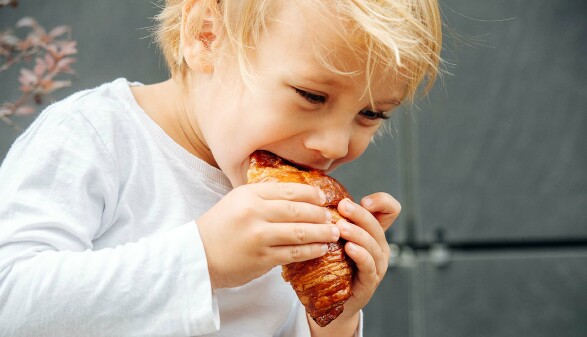 Kind isst Croissant