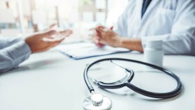 Hände von Arzt und Patient, ohne Gesicht. Vorne Stethoskop