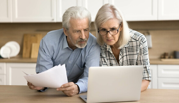 Pensionistenpaar schaut auf Laptop