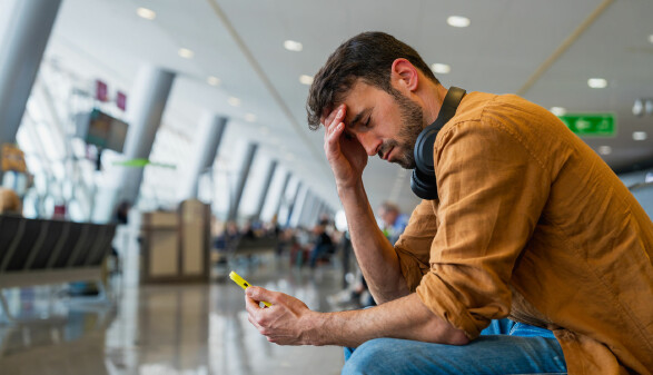 Ein Mann sitzt am Flughafen und wartet auf seinen Flug
