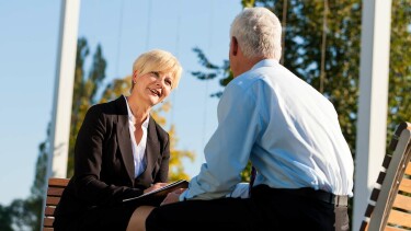 Frau im Bussinessoutfit unterhält sich mit Mann, der ihr zugewandt ist