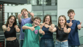 Eine Gruppe Jugendlicher steht im Innenhof der AK Linz