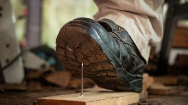 Tritt mit Arbeitsschuh auf Nagel