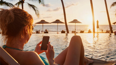 Frau surft im Urlaub am Handy