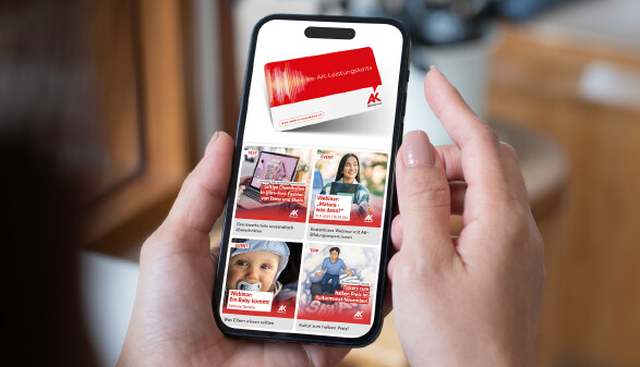 Eine Person hält ein Smartphone in der Hand, auf dessen Bildschirm die aktuellen Vorteile der Arbeiterkammer Oberösterreich mit der AK-Leistungskarte.