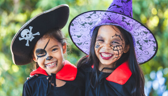 Zwei verkleidete und gruselig geschminkte M&auml;dchen in Halloween-Kost&uuml;men.