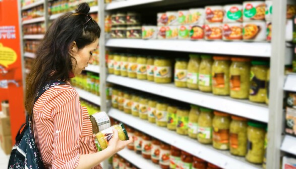 Frau steht vor Supermarkt-Regal